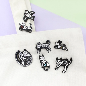 Detail of creative animal skeleton enamel pins on white canvas bag straps and surface