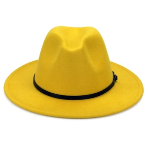Detail of yellow wool fedora hat with black leather strap and metal buckle close-up
