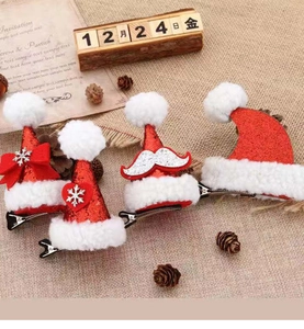 Detailansicht von vier Mini-Weihnachtsmützen-Haarspangen mit roten Pailletten und Fell