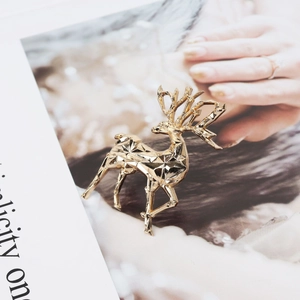 Close-up of golden geometric deer brooch with metallic luster and stylish design