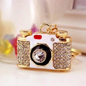Exquisite gold-plated camera keychain with sparkling white rhinestones and a large crystal lens
