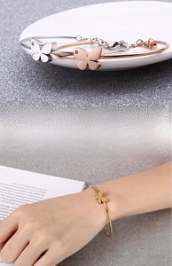 Detail of butterfly open bangle showing rust resistance and model hand wearing demonstration