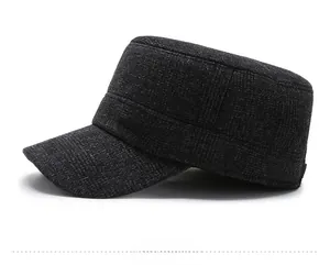 Close-up of grey plaid woolen fabric and metal NP logo on men's winter flat cap