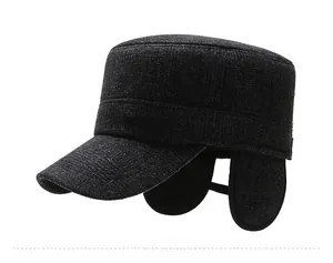 Detailed side view of grey winter flat cap with ear flaps and metal logo detail