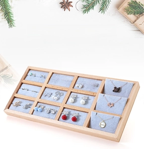 Close-up of 12-slot beech wood jewelry display tray with soft light blue velvet lining