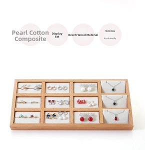Detail of 12-slot beech wood jewelry tray with velvet lining and various accessories