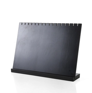 Close-up of black wooden necklace display stand with grooves and natural wood grain