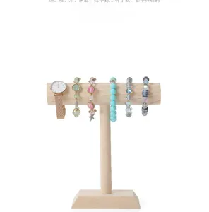 Detail of wooden T-bar stand showing rose gold watch and assorted beaded bracelets