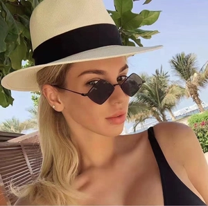 Detail of rhombus geometric sunglasses and panama straw hat for a summer beach look