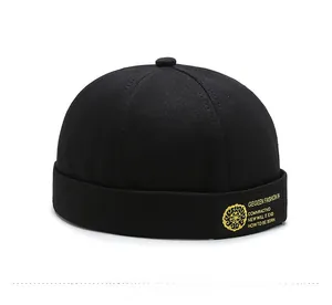 Detail of black cotton docker cap featuring a yellow embroidered streetwear brand label
