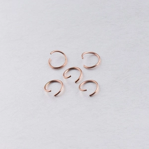 Detailed view of rose gold stainless steel jump rings for DIY jewelry making connections