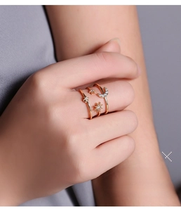Detailed view of rose gold triple-layer star and moon rings with zircon accents on hand