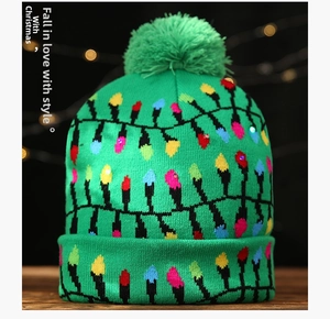Texture de maille de bonnet de Noël vert avec paillettes festives et pompon doux assorti