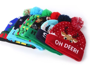 Detail of colorful knitted Christmas hats with LED lights, festive deer and snowflake patterns