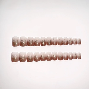 Pink gradient press-on nails with gold foil accents on a clean white background