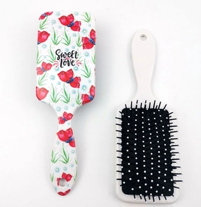 Detail of white plastic paddle brush featuring Sweet Love print and black massage bristles