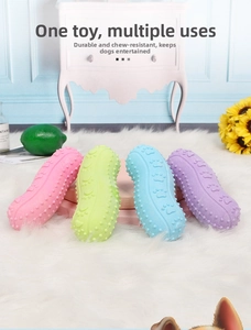 Peanut-shaped rubber dog chew toys in pastel colors displayed on a white plush carpet