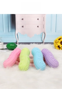 Peanut-shaped rubber pet toys in macaron colors with massage texture on a plush rug