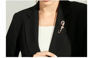 Rose gold safety pin brooch with white crystals on black blazer lapel for luxury style