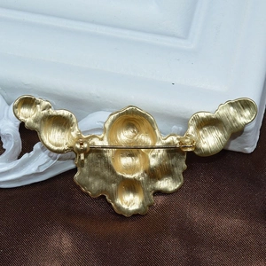 Detailed back view of matte gold unicorn brooch showing safety pin clasp mechanism