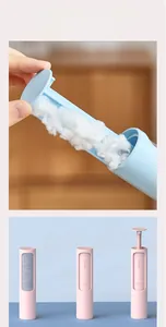 Détail de la brosse anti-poils pour animaux avec bouton de nettoyage en bleu et rose