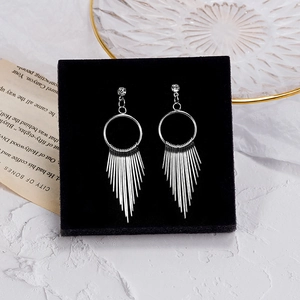 Detail of silver geometric tassel earrings with rhinestones on a black velvet stand