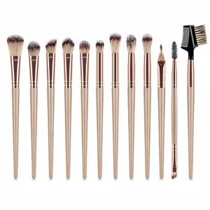 Flat lay of 12-piece champagne gold makeup brush set with soft grey gradient bristles