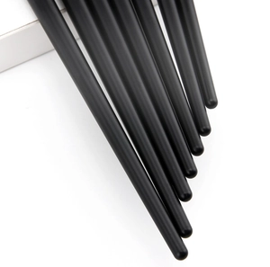 Close-up of sleek black makeup brush handles with champagne gold metallic accents