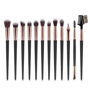 Set of 12 makeup brushes with black handles and rose gold ferrules on white background