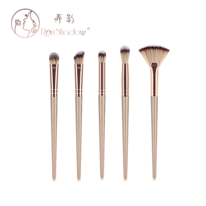 Detailed set of 5 professional makeup brushes with champagne gold handles on white background