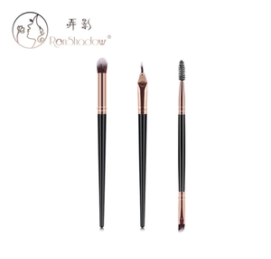 Detail of 3 professional makeup brushes with black handles and rose gold ferrules