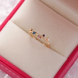Close-up of gold flower ring with colorful zirconia stones on a velvet jewelry box