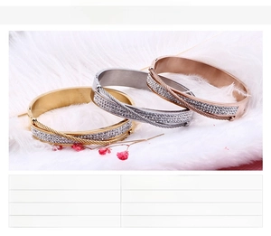 Three-color titanium steel bracelets with cubic zirconia on white feather background