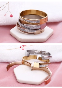 Detailed view of 18k gold-plated hinged bangles featuring pavé crystals and twisted steel