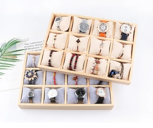 Details eines 12er Holz-Uhren-Displays mit weichen Kissen in Beige und hellem Grau