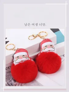 Detail of red plush ball Santa Claus keychain with golden keyring on white props