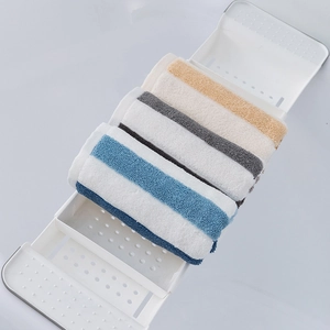 Absorbent thick cotton towels with colored stripes displayed on a white bathtub caddy