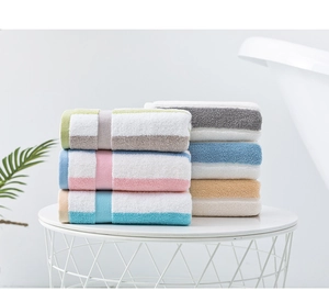 Detailed stack of soft striped cotton towels in various colors on a modern table