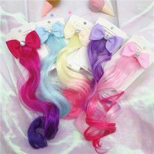 Detail of colorful unicorn rainbow hair extensions with glitter bows and heart gems
