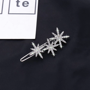 Elegant silver snowflake and star hair clip with sparkling rhinestones on black background