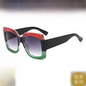 Vue détaillée des lunettes de soleil carrées avec un motif unique tricolore rouge noir et vert