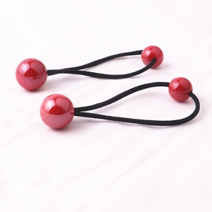 Dettaglio di due elastici per capelli con perline rosse e bande nere per bambine