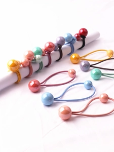 Dettaglio di elastici per capelli per bambine con doppie sfere colorate su supporto