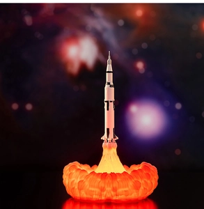 3D printed rocket lamp with glowing orange flame base against deep space nebula background