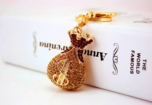 Macro shot of gold money bag keychain with sparkling rhinestones and dollar symbol