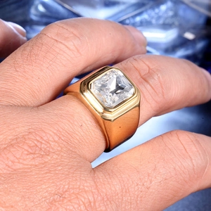 Détail macro d'une bague chevalière dorée pour homme avec une grande pierre carrée