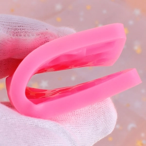 Close-up of flexible pink silicone jewelry mold being bent to show material elasticity