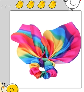 Detailed view of rainbow satin hair scrunchie with large bow and silky texture