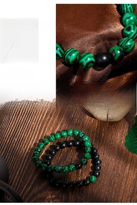 Macro detail of matte black agate and green malachite texture beaded bracelet set