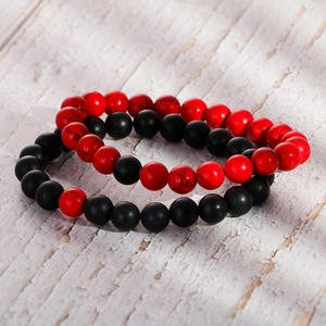 DIY 8mm matte black agate and red turquoise beaded couple bracelets on white wood background